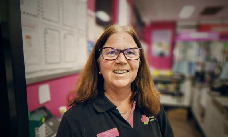 Vicki Marsh, a pharmacy assistant at Priceline Pharmacy Moree, at the store counter before her fundraising buzz cut.